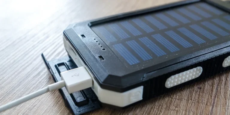 A close-up of a solar charger with a USB connection on a wooden surface