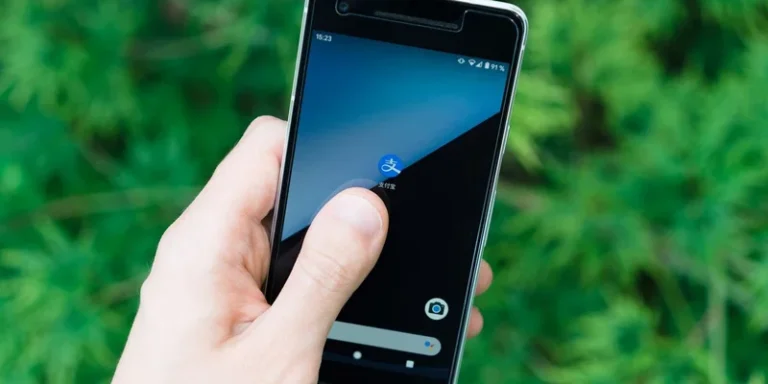 Hand holding smartphone with app icon on screen