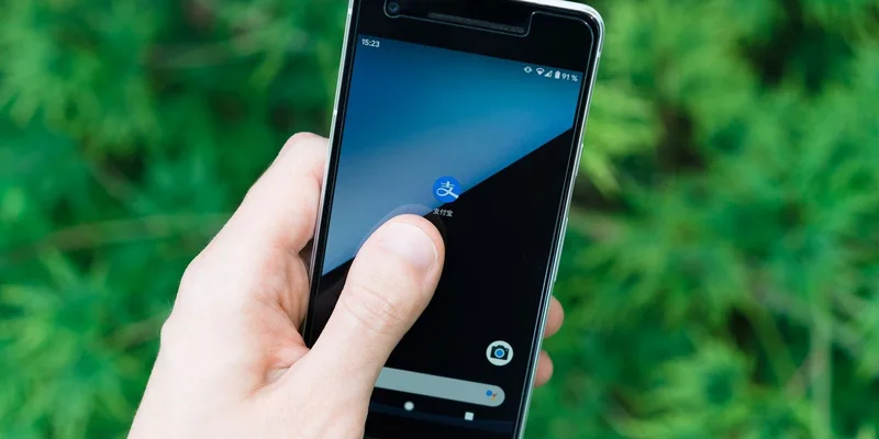 Hand holding smartphone with app icon on screen