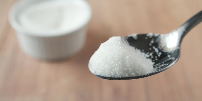 A close-up shot of granulated sugar on a spoon